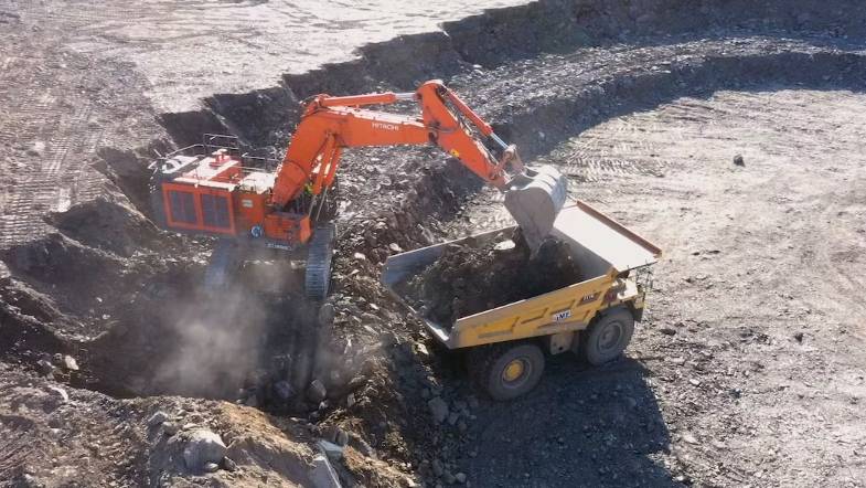 Una excavadora arroja tierra al camión cantera de Cristina Carro